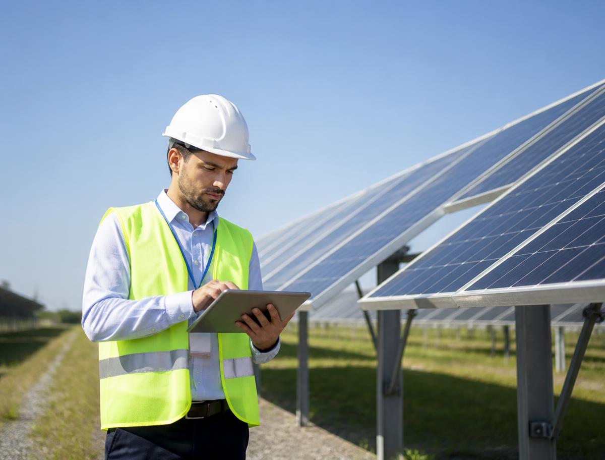 Engenheiro inspecionando os painéis de uma usina de energia solar